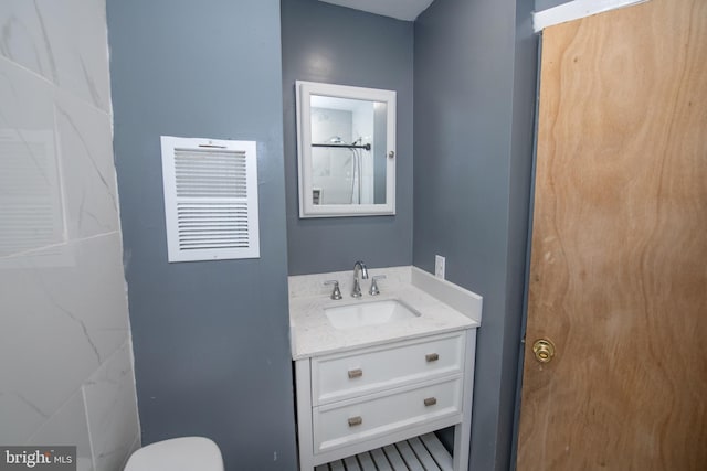 bathroom featuring vanity, toilet, and a shower