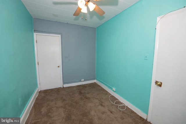 unfurnished room featuring ceiling fan and dark carpet