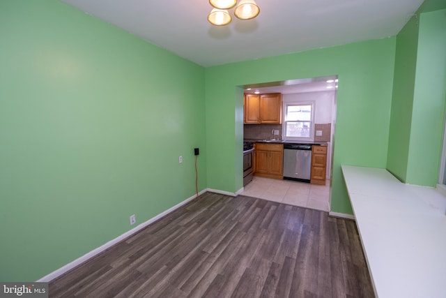 kitchen featuring tasteful backsplash, appliances with stainless steel finishes, and light wood-type flooring