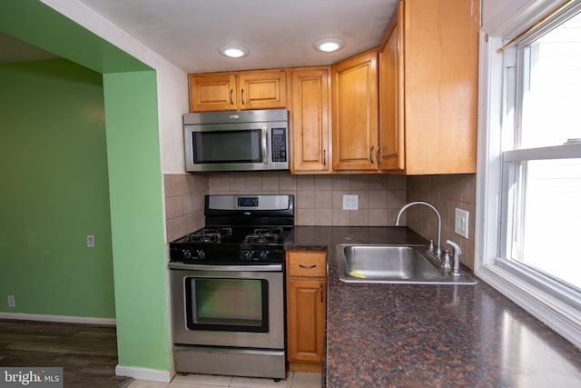 kitchen featuring stainless steel appliances, plenty of natural light, sink, and backsplash