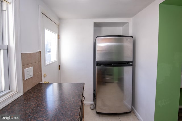 kitchen featuring light tile patterned floors and stainless steel refrigerator