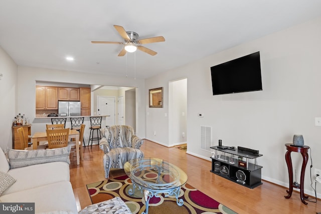 living room featuring light hardwood / wood-style flooring and ceiling fan