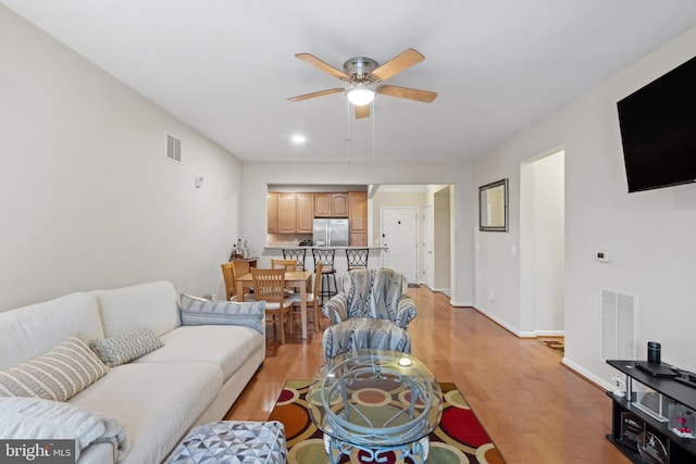 living room featuring light hardwood / wood-style flooring and ceiling fan