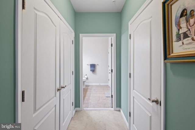 hallway featuring light colored carpet