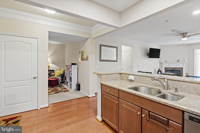 kitchen featuring sink, light stone countertops, light hardwood / wood-style floors, and dishwasher