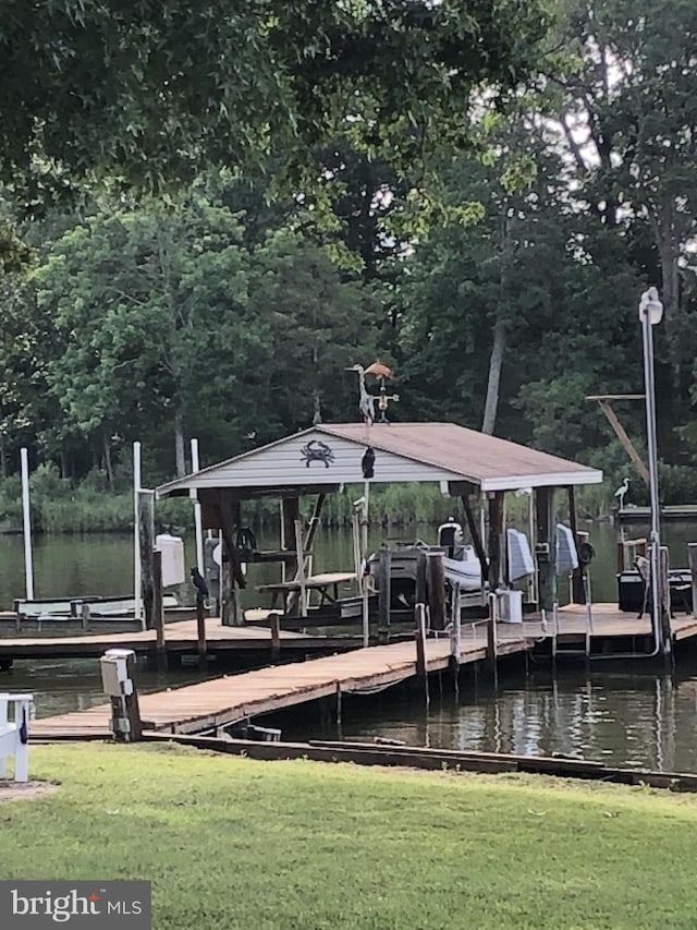 view of dock featuring a water view and a yard