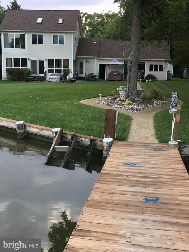 dock area featuring a water view and a yard