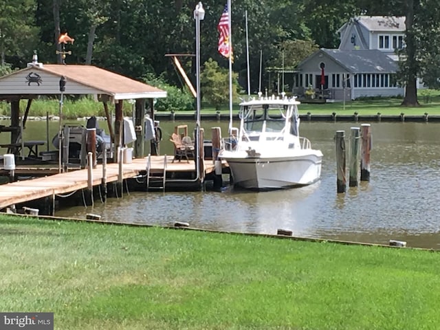 view of dock with a water view and a yard