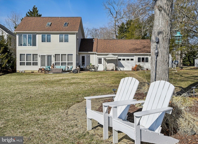 rear view of house with a patio area, roof with shingles, a lawn, and an attached garage