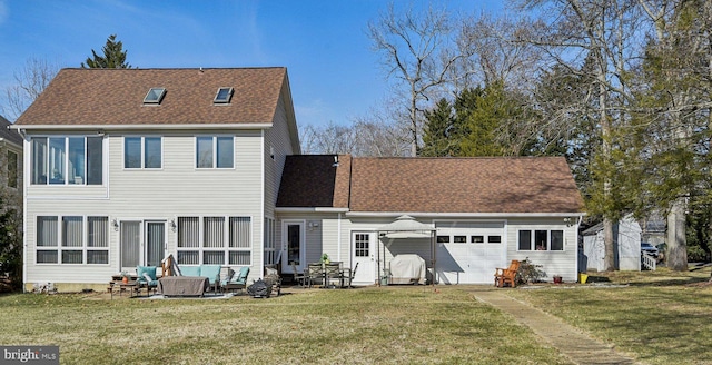 back of property with a shingled roof, a yard, driveway, and a garage