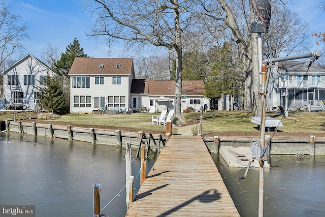 view of dock with a water view and a yard