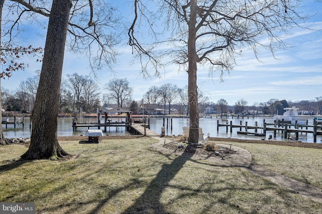 dock area featuring a water view and a yard