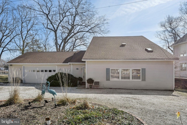 exterior space with a shingled roof and driveway