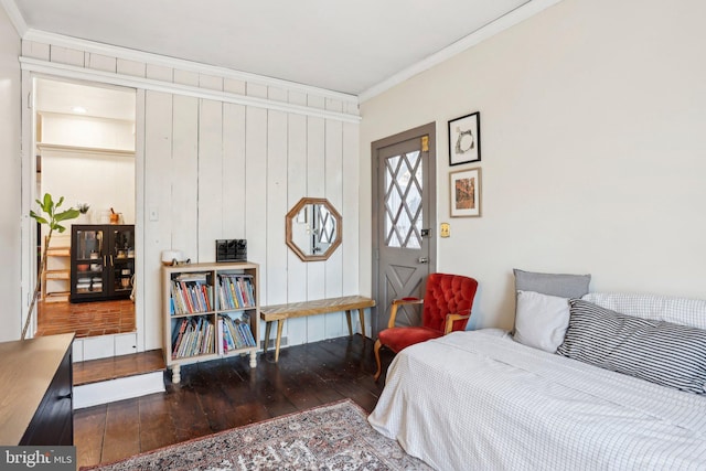 bedroom with ornamental molding and dark hardwood / wood-style floors