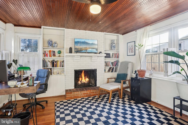 office area with a brick fireplace, a healthy amount of sunlight, wood ceiling, and dark hardwood / wood-style floors