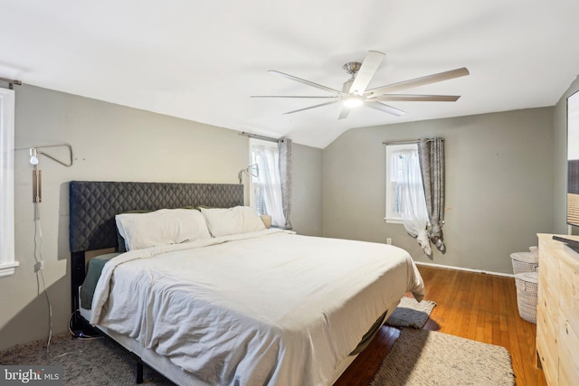 bedroom featuring hardwood / wood-style floors, vaulted ceiling, and ceiling fan