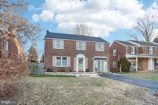 colonial home with a front lawn