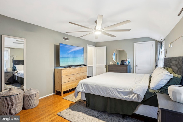 bedroom with lofted ceiling, hardwood / wood-style floors, ceiling fan, and a closet