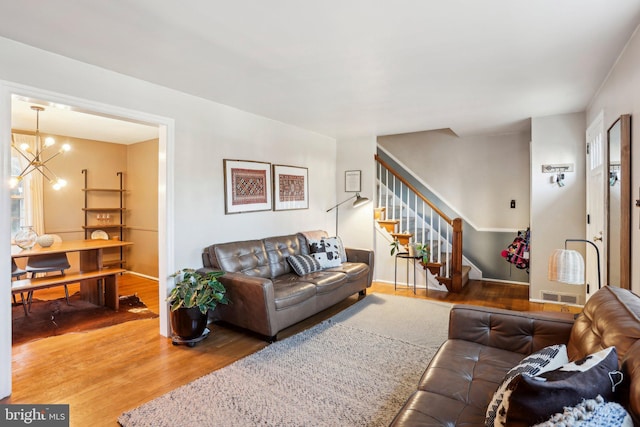 living room with hardwood / wood-style flooring and a notable chandelier