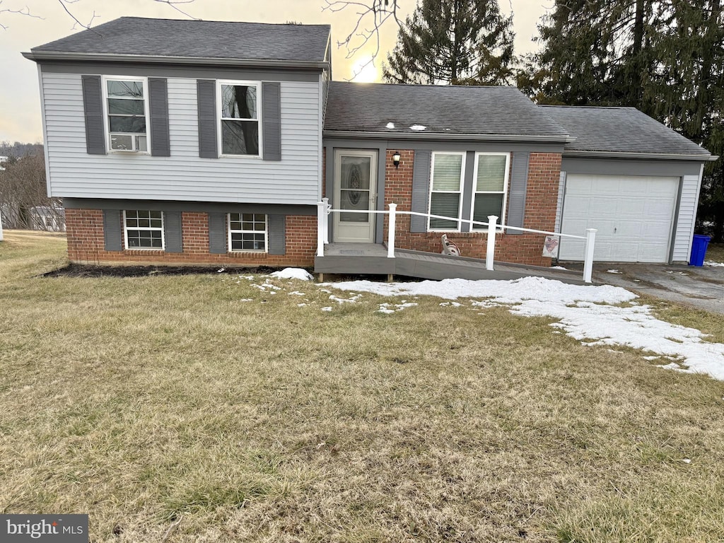 split level home featuring a garage and a lawn