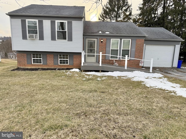 tri-level home with a garage and a lawn