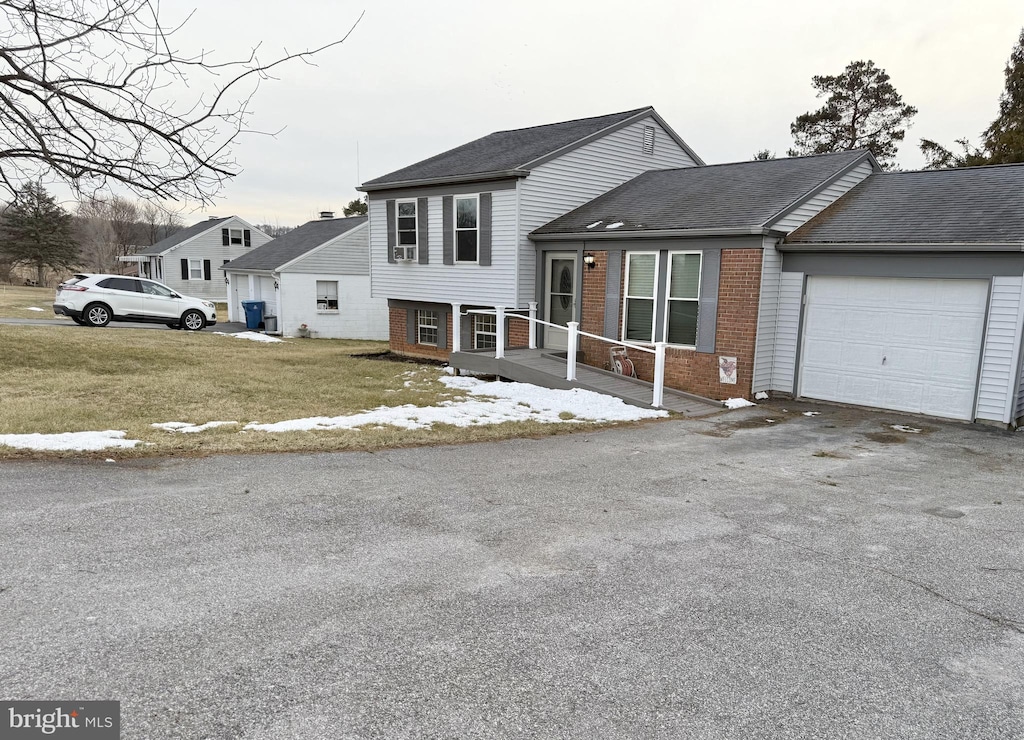 tri-level home featuring a garage and a front yard