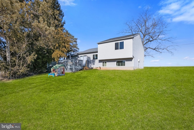 rear view of house featuring a lawn and a wooden deck