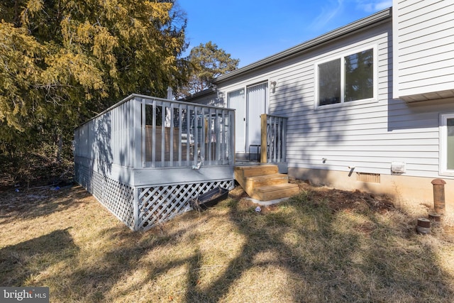 rear view of property with a deck and a lawn