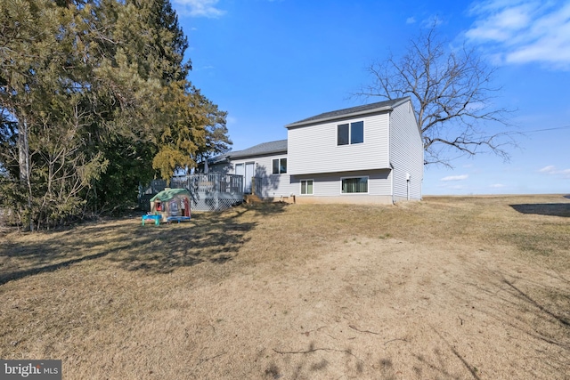 back of property with a wooden deck and a lawn