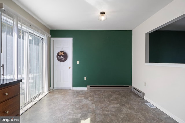 interior space with baseboard heating and a wealth of natural light