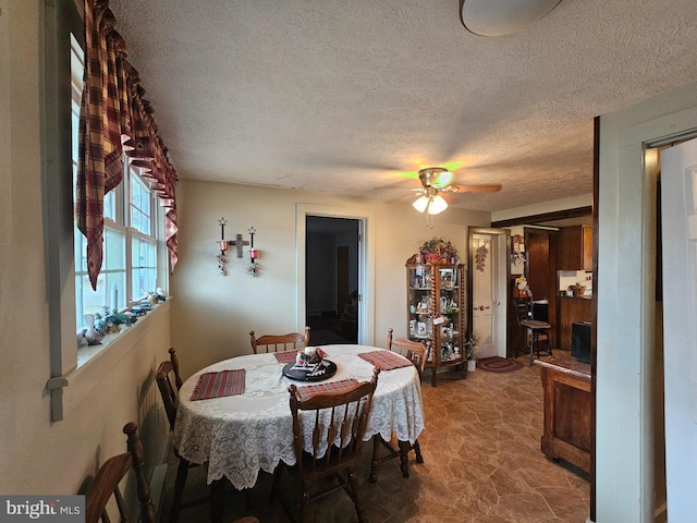 dining room with a textured ceiling and a ceiling fan