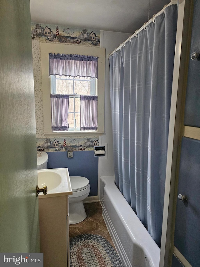 full bathroom featuring tile patterned flooring, toilet, vanity, baseboards, and shower / bath combo with shower curtain