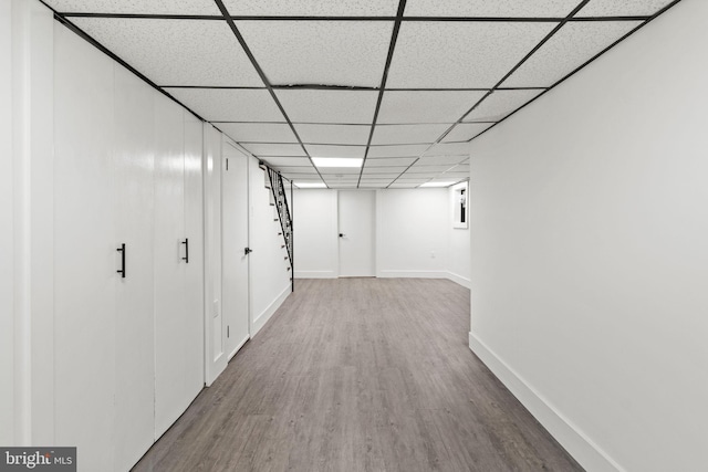 corridor featuring hardwood / wood-style flooring and a paneled ceiling