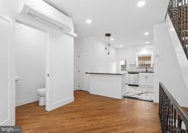 interior space featuring a wall mounted air conditioner, sink, and wood-type flooring