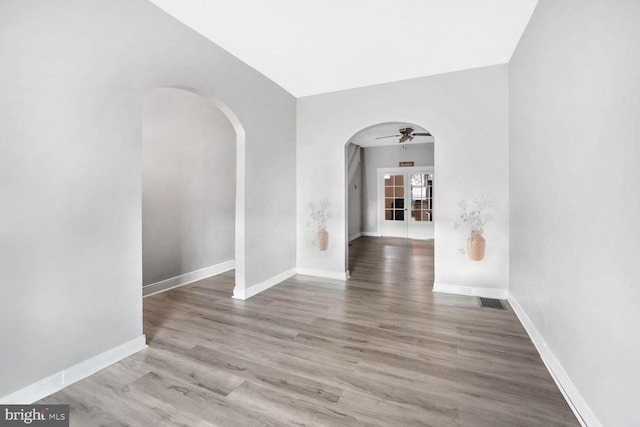 unfurnished room featuring hardwood / wood-style flooring, ceiling fan, and french doors