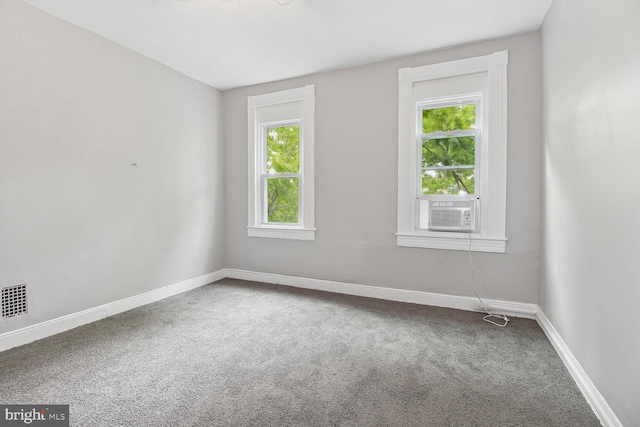 unfurnished room with carpet, a wealth of natural light, and cooling unit