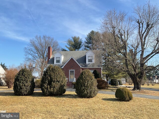 cape cod-style house with a front lawn