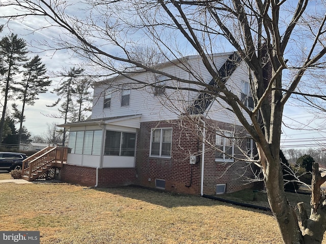 view of side of property with a lawn and a sunroom