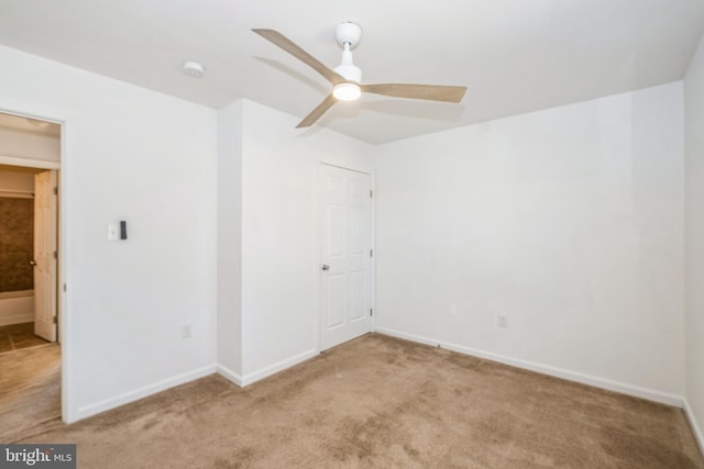 carpeted spare room featuring ceiling fan