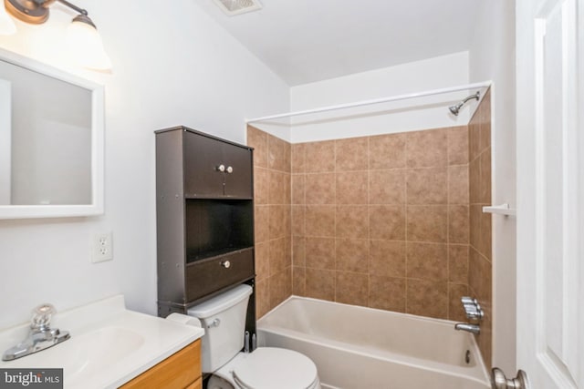 full bathroom with tiled shower / bath, vanity, and toilet