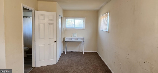 hall with dark colored carpet