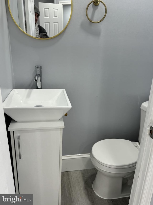 bathroom with wood-type flooring, toilet, and vanity