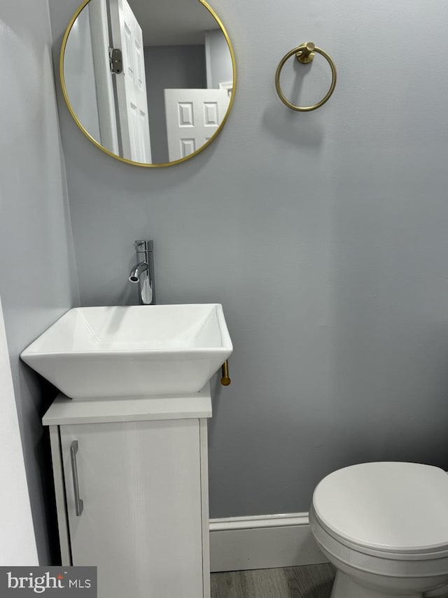 bathroom featuring hardwood / wood-style flooring, vanity, and toilet