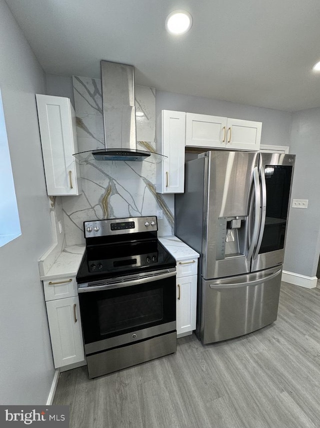 kitchen with white cabinetry, stainless steel appliances, and wall chimney range hood