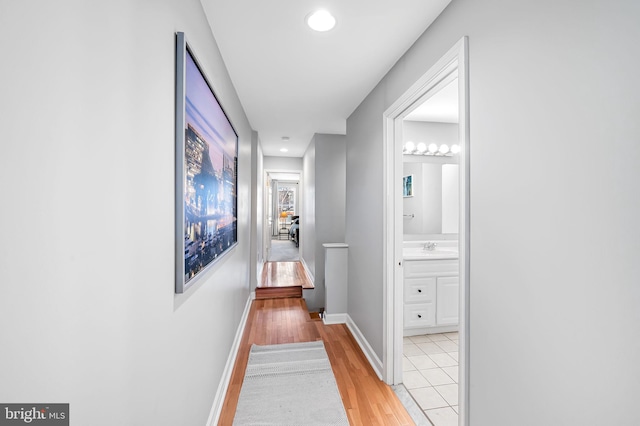 hallway featuring sink and light wood-type flooring