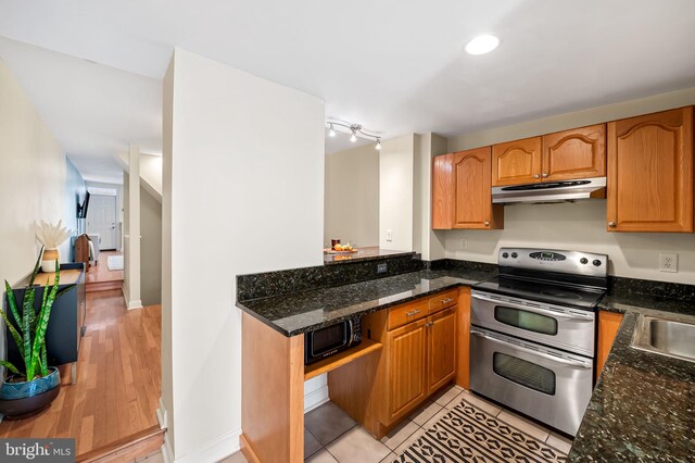 kitchen featuring range with two ovens and dark stone countertops