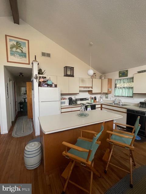 kitchen with lofted ceiling with beams, dishwasher, electric range oven, and dark hardwood / wood-style floors