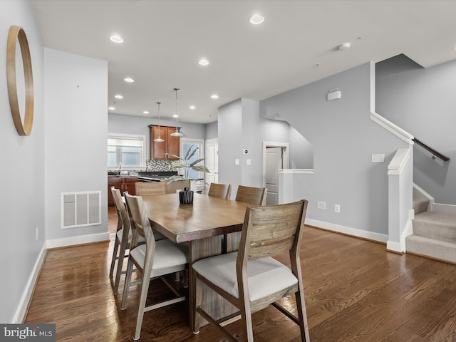 dining room with sink and dark wood-type flooring