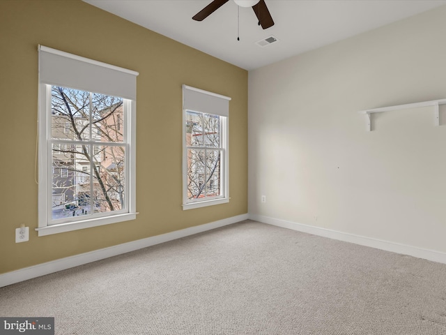 carpeted spare room featuring ceiling fan