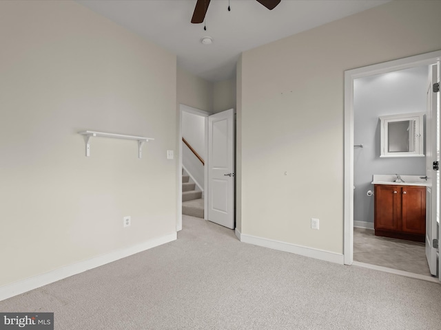 unfurnished bedroom featuring light colored carpet, sink, and ensuite bath